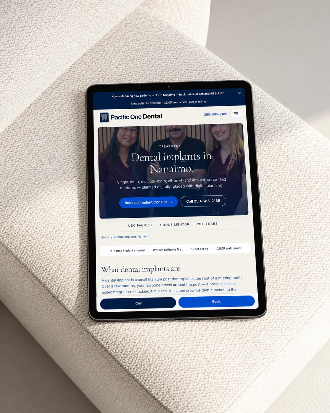 Pacific One Dental archived build: dental implants page on a tablet, on a white stone surface