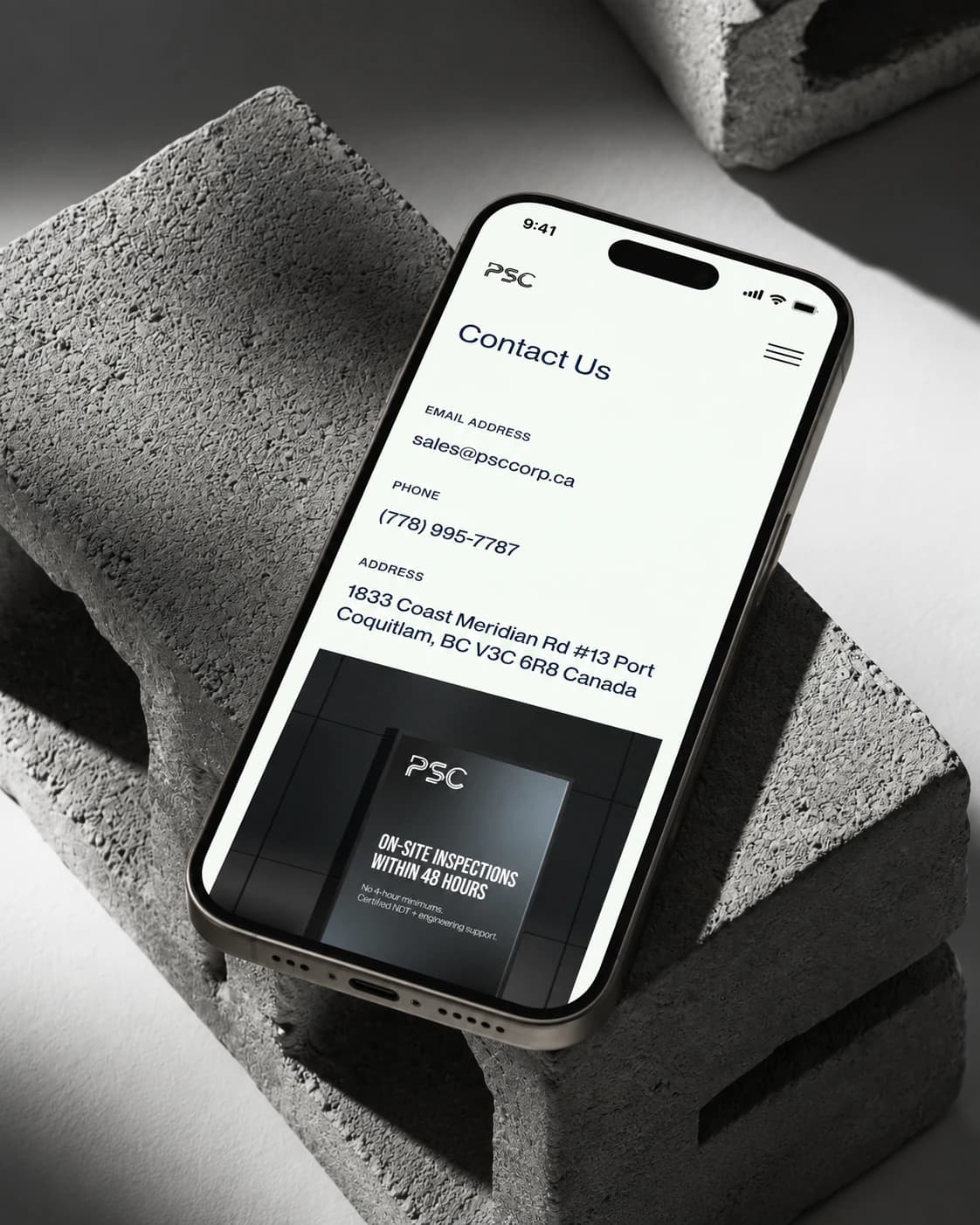PSC contact page on a phone, on a concrete block