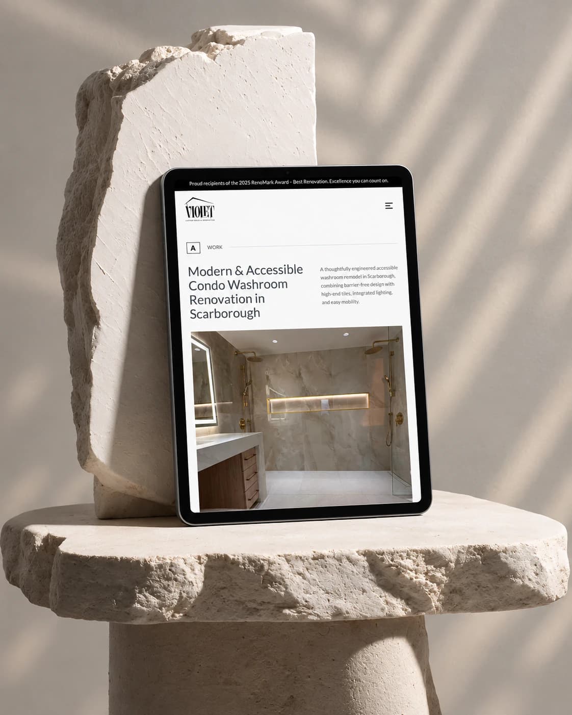 Violet Build Scarborough accessible condo washroom project page on a tablet, on a stone plinth