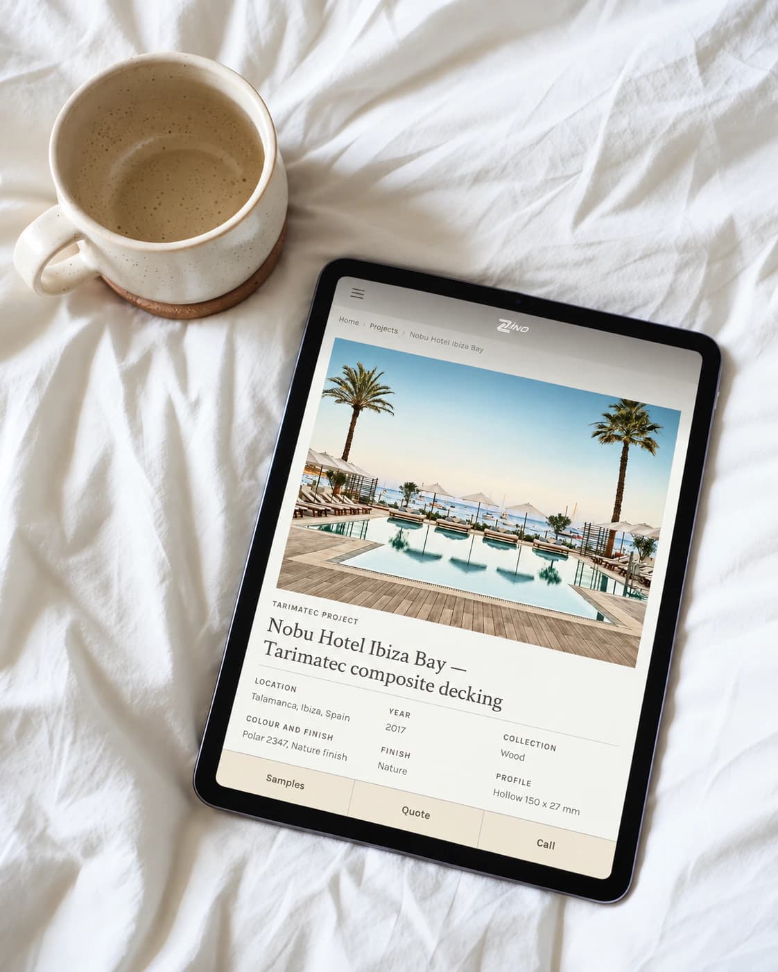 Zinodeck Nobu Hotel Ibiza Bay project page on a tablet, resting on bed linen beside a coffee cup
