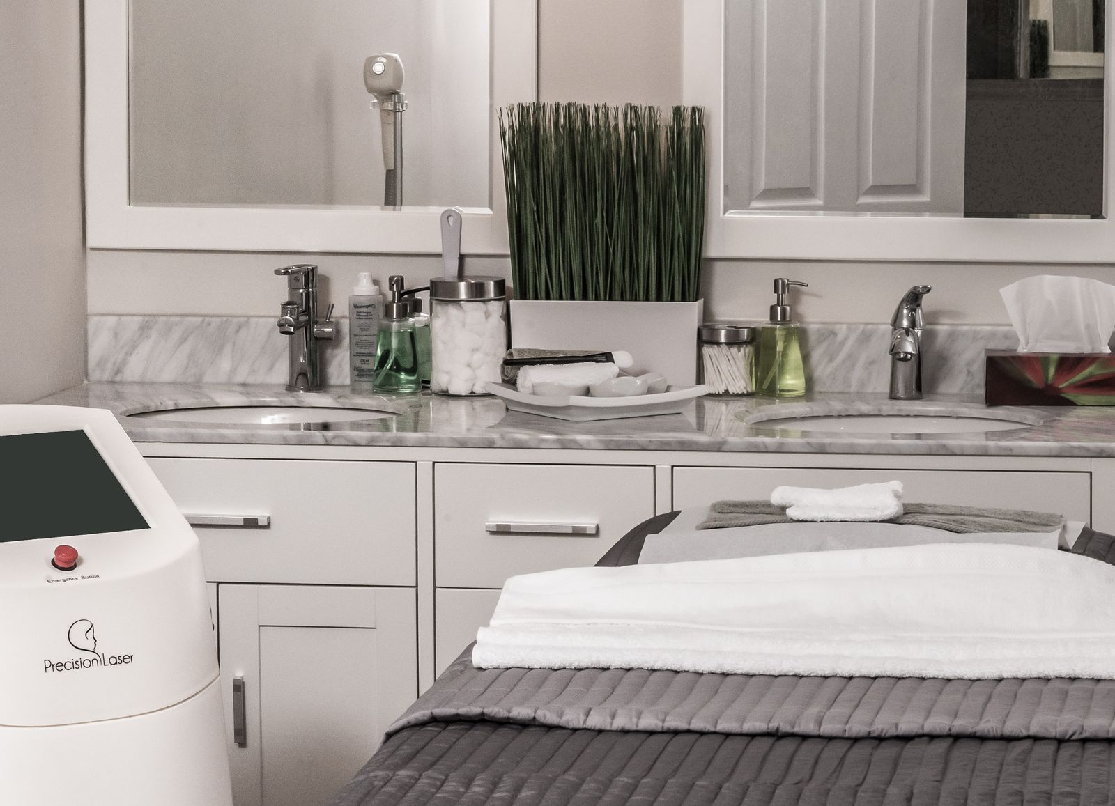 Empty medspa treatment room with a laser device and nobody in the chair — the open slot a reactivation sequence fills.